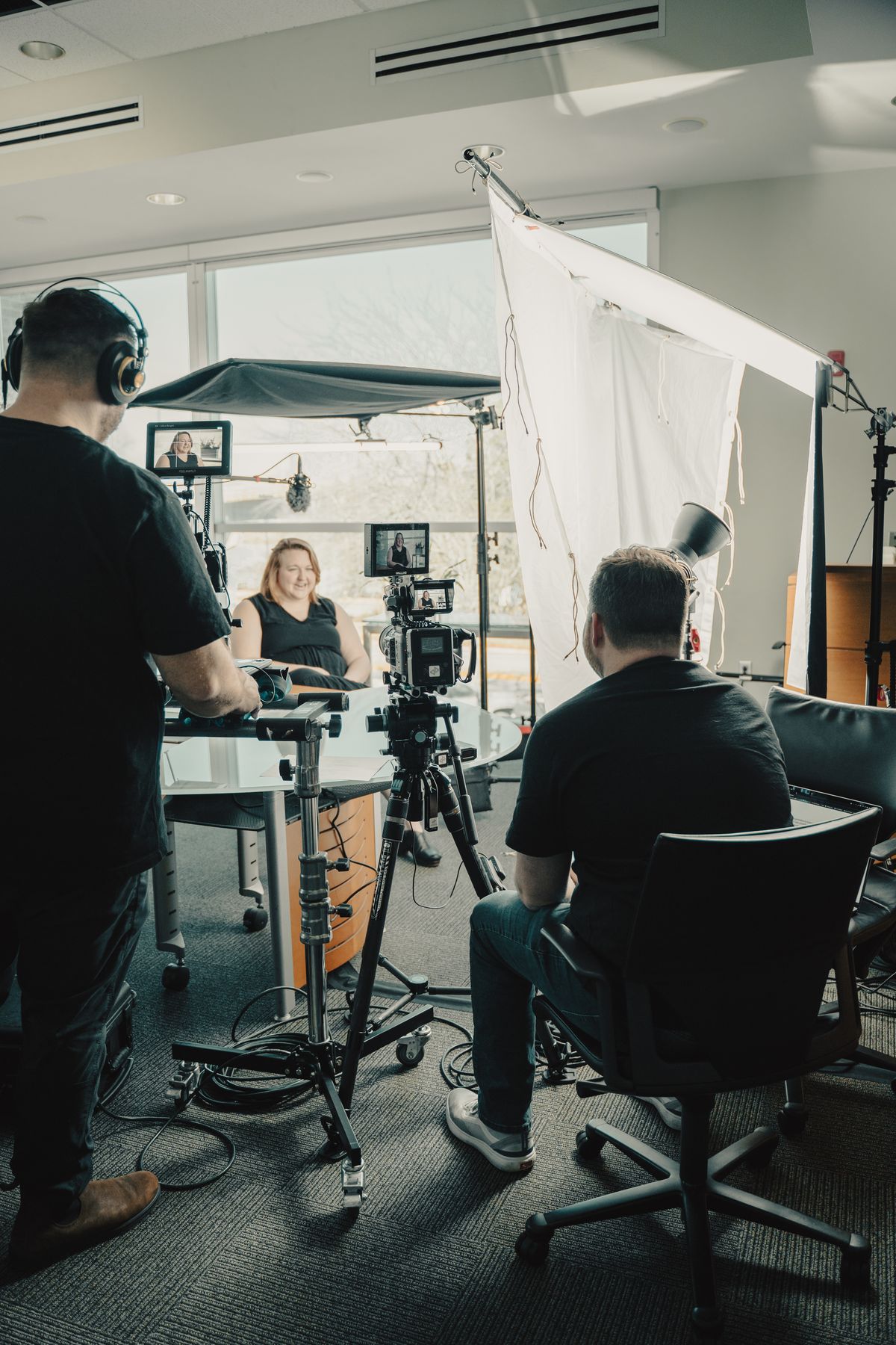 Professional cinema camera with telephoto lens mounted on a dolly system during a corporate video production
