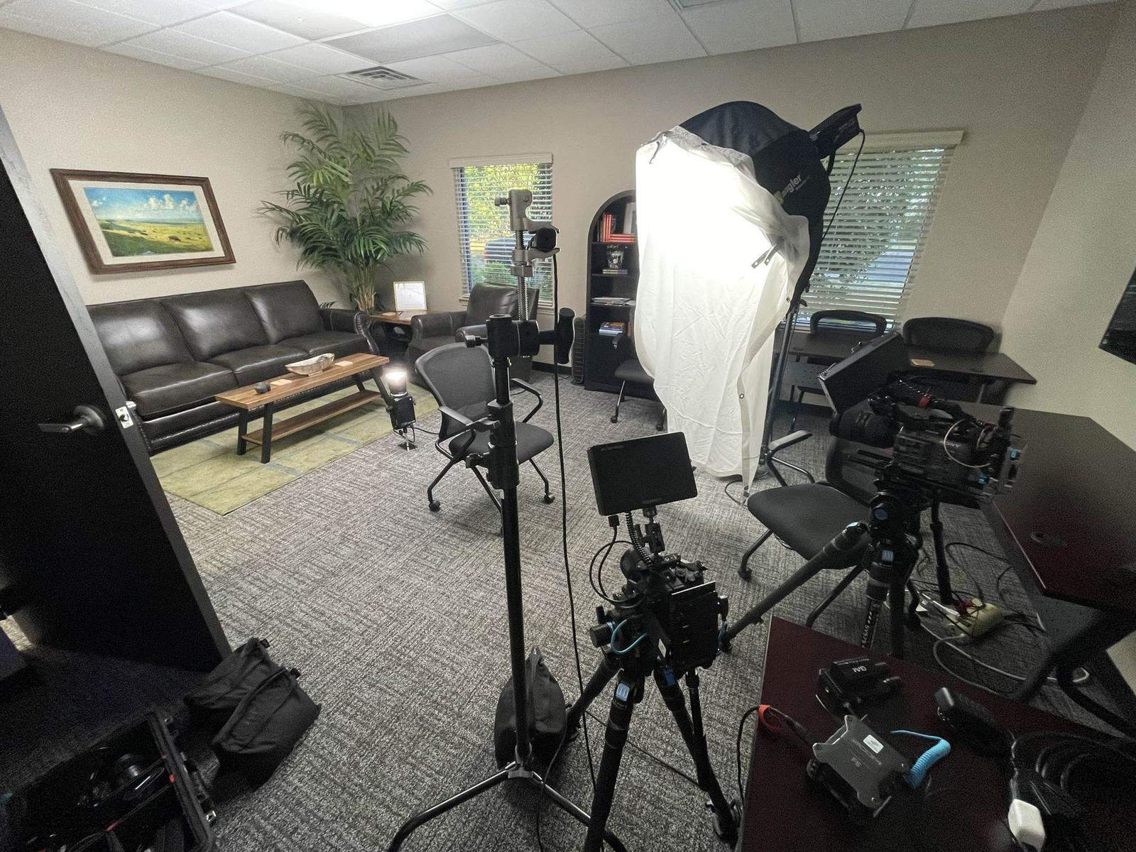 A documentary-style interview lighting and camera setup arranged inside an office for a business video shoot in Arkansas