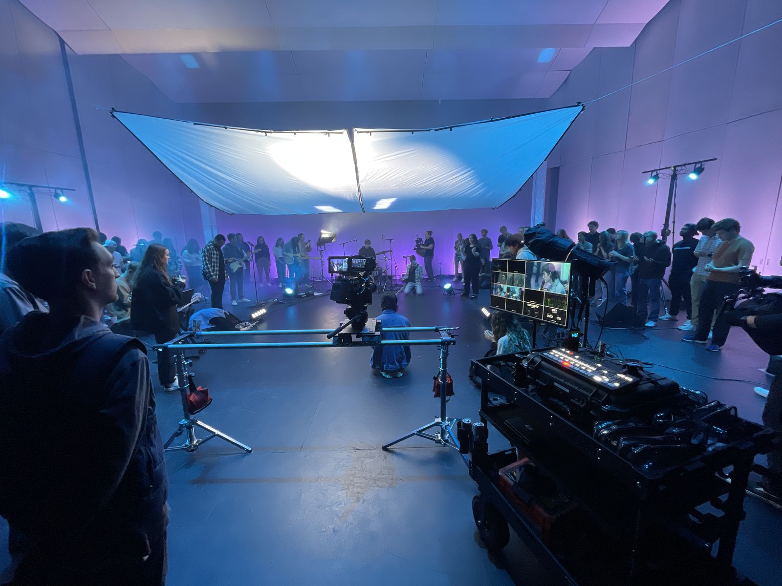 Large-scale video production in Arkansas with full crew, stage lighting, and multiple camera operators at a university event