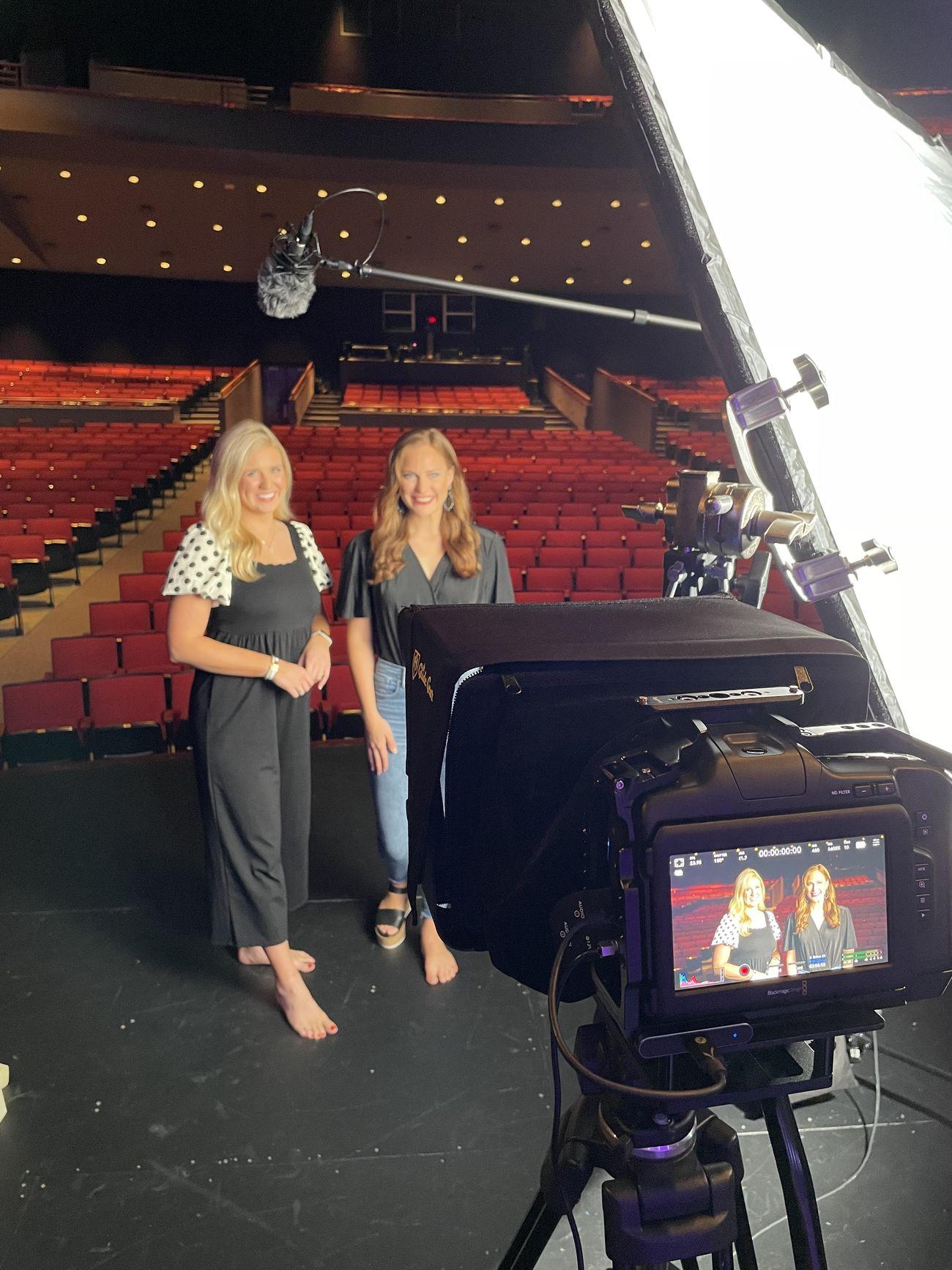 Two people being filmed on camera on a theater stage during a video interview in Arkansas