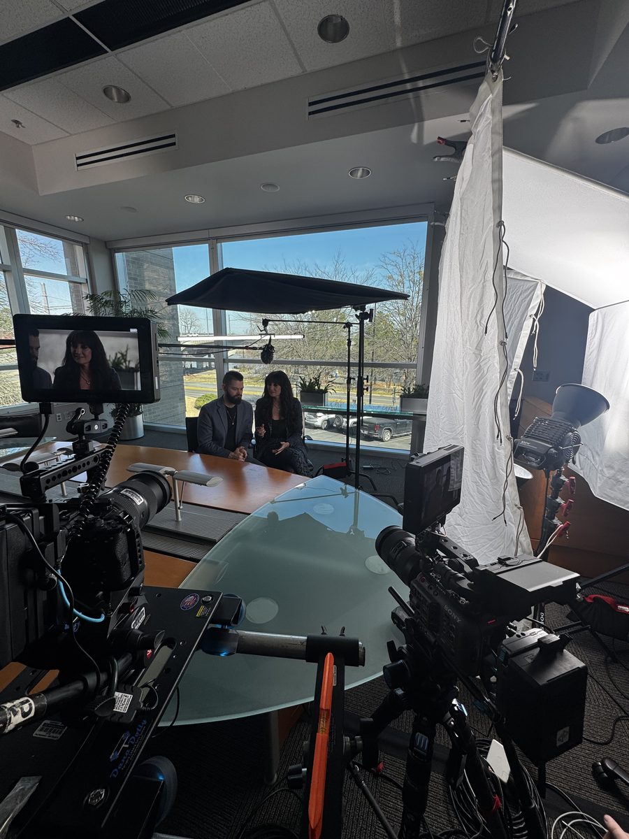 Documentary-style nonprofit interview production in Arkansas with professional lighting and crew filming a subject at a glass table