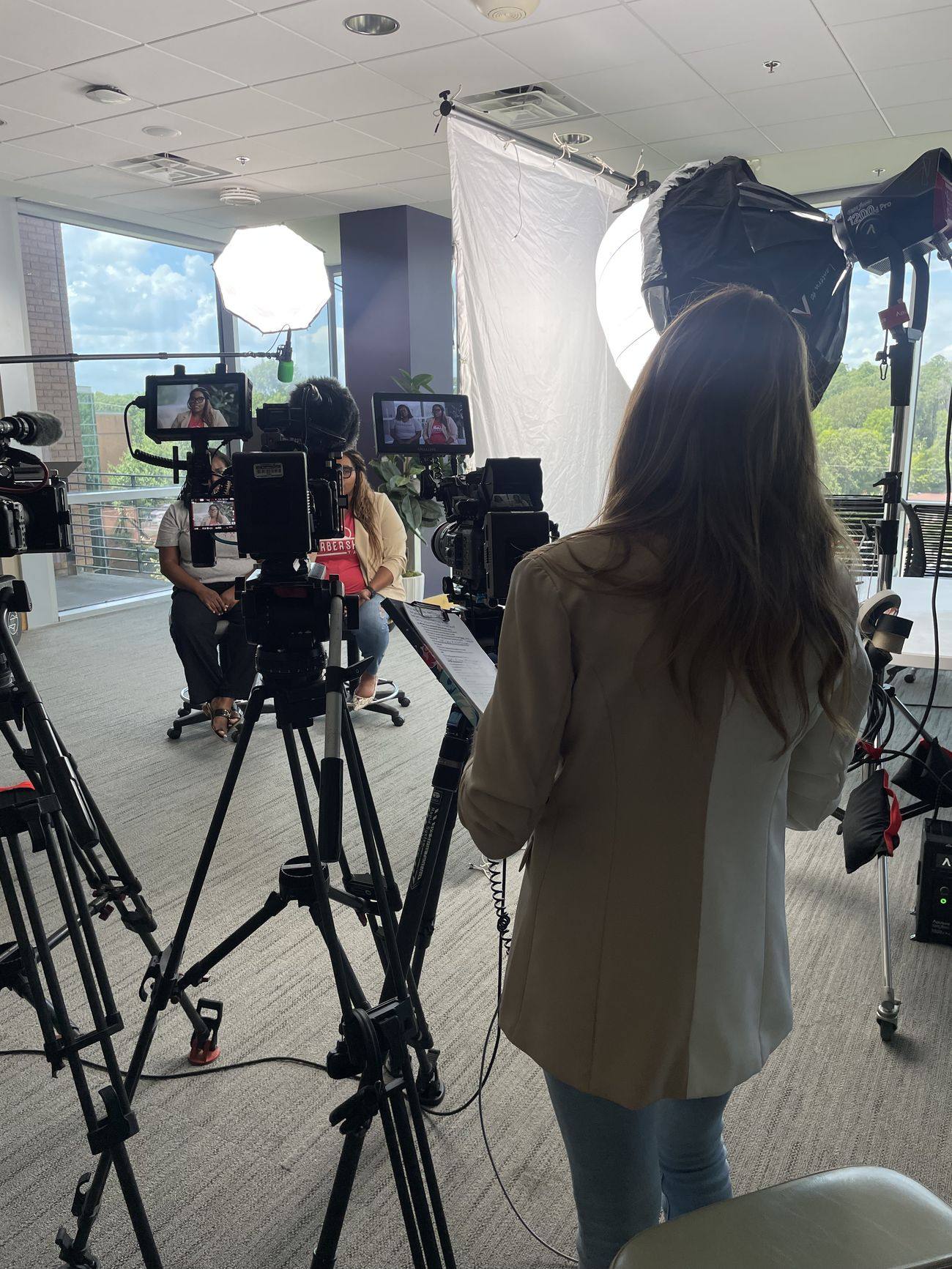 Video production crew filming an interview subject with professional softbox lighting for a nonprofit video in Arkansas