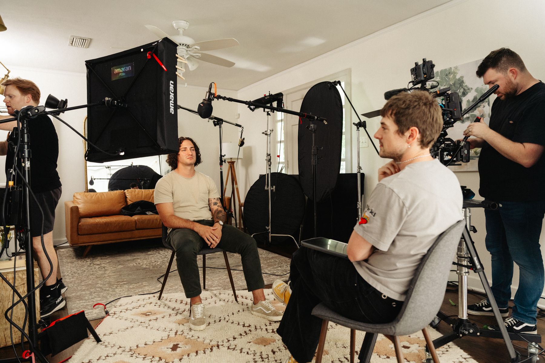 Documentary-style customer testimonial video production in Arkansas with professional lighting, multiple crew members, and on-camera talent during an interview